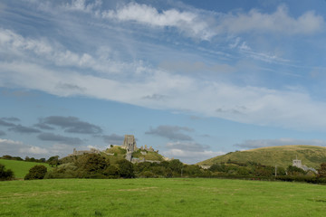 View over fields to Corfe Castle above graveyard, Dorset