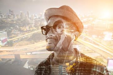 Young hipster man in earphones holding smartphone isolated on th