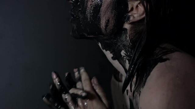 4k shoot of a horror Halloween model - Woman washing off black mud from face