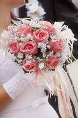 Wedding bouquet in hands of the bride in a white dress