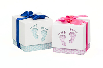 Two small boxes with gift for a newborn baby, pink and blue polka dots, top decorated with bow 