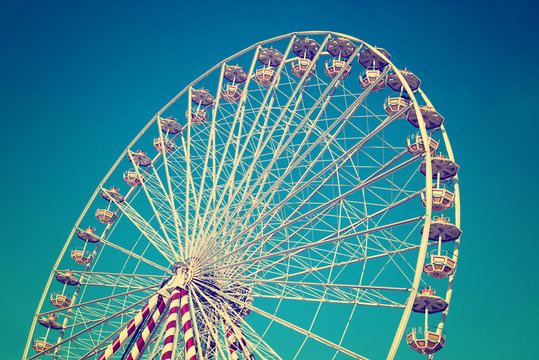circular big ferris wheel on blue sky background vintage filtered image