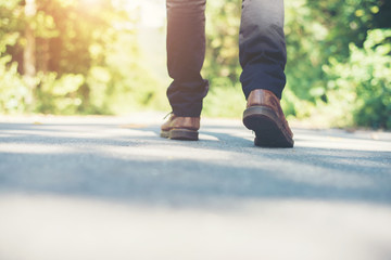 Man feet walking on the rural road on vacation. Holiday tourism
