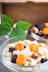 One serving of oatmeal with fruit in a glass bowl