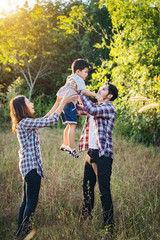 Fototapeta premium Happy young family spending time together outside in green natur