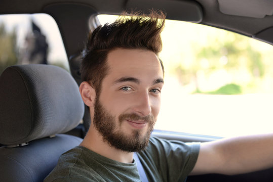 Portrait of successful young man sitting in car