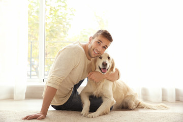 Handsome man with cute dog at home