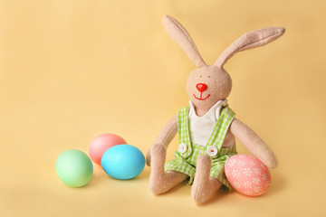 Colorful Easter eggs and bunny on yellow background