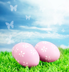 Easter eggs on green grass against sky background