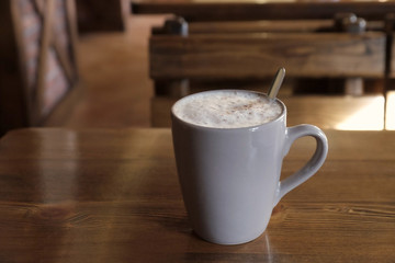Cup of fresh coffee on wooden table