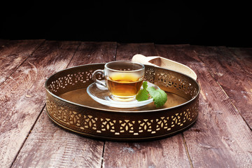 Tea. Herbal tea. Mint leaf. Tea in a glass cup, mint leaves, dried tea, sliced lime. herbs and mint leaves on a slate plate in a restaurant or teahouse tea room.