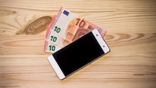 Smartphone und Geldscheine auf Holzuntergrund, Breitbild