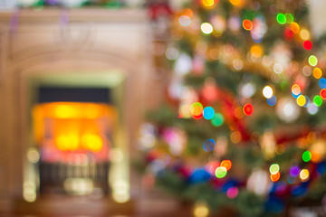 Blurred Christmas background with a fireplace and a Christmas tree.