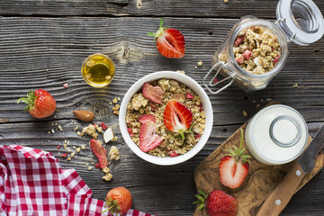 Healthy breakfast. Strawberry granola with almond petals and fresh berries. Served  milk, honey  mint. Top view
