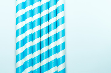 Baby blue striped straws. Party background.
