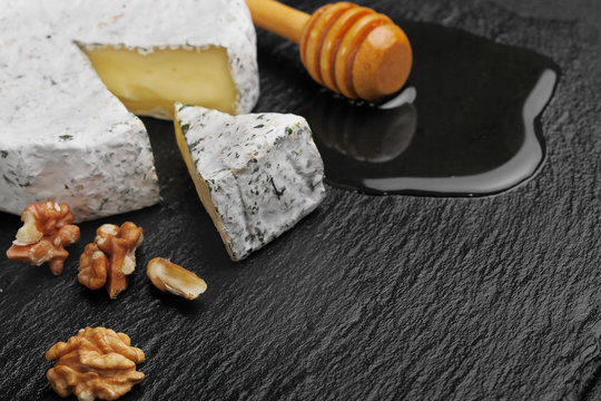 Camembert cheese with nuts on spoon for honey and honey dark slate background.copy space.selective focus