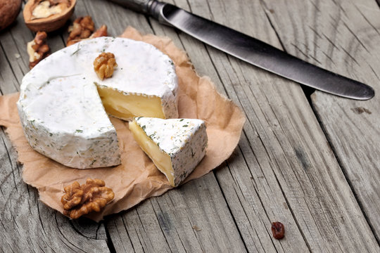 Creamy Camembert with nuts,raisins and on rustic wooden background.selective focus