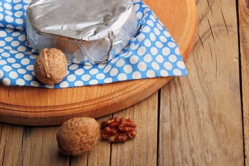 Camembert and brie cheese on wooden background with nuts spices and honey. Italian food.