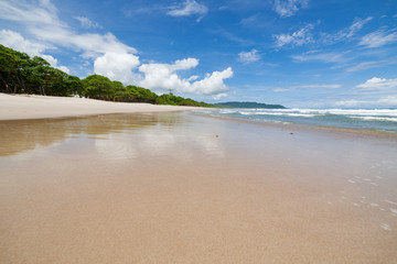 Waves sand beach and clouds sunny day