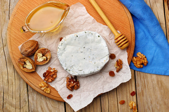 Camembert and brie cheese on wooden background with nuts spices and honey. Italian food. top view