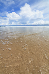 Waves sand beach and clouds sunny day
