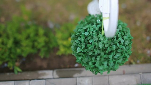Decorative green ball hangs over the pavement