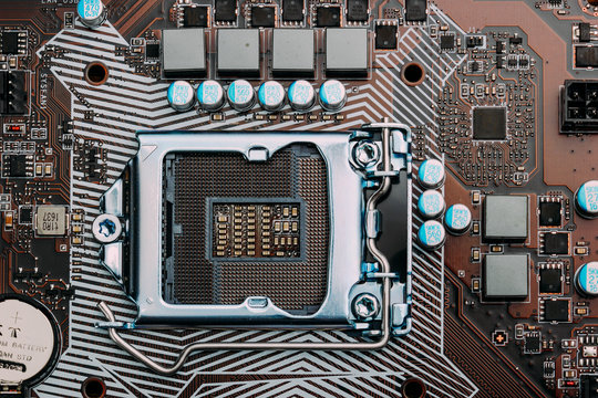 Empty cpu processor socket on a computer motherboard with pins visible. Blue toned.
