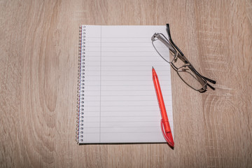 Einkaufsliste auf einem Tisch mit Brille und Kugelschreiber
