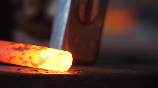 Forging hot metal in smith with hand hummer
