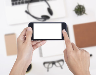 Business hand holding smart phone with white screen isolated on desk office background.