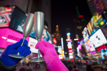Couple does a Champagne toast against the bright lights of Times Square as the city prepares for New Year's Eve