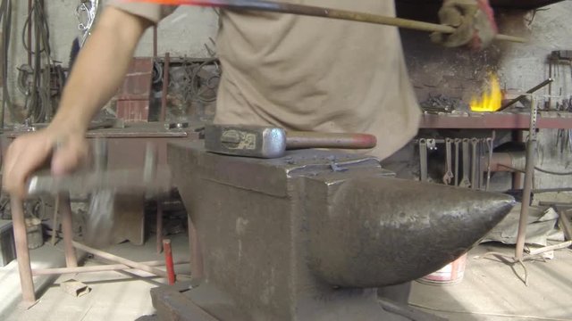 Forging hot metal in smith with hand hummer