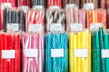 Bunches of candy sticks in different colors wrapped in plastic cellophane. Shallow depth of field,...