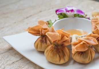 Deep fried Chinese sheet wrap minced pork by shallot with sweet sauce call gold bag in Thai.Thai appetizers