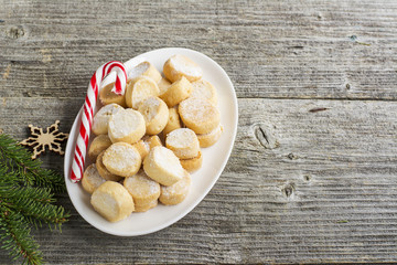 Domestic oil small round cookies in the form of coins on the feast  sweet cane and fir branches. Top view