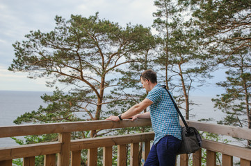 man sitting on the wooden stairs in park and smiling