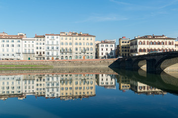 Fototapeta na wymiar View of Arno river embankment with architecture and buildings a