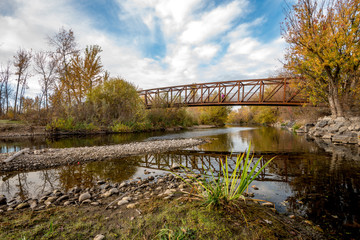Fototapeta na wymiar Walker crosses a foot bridge in the fall