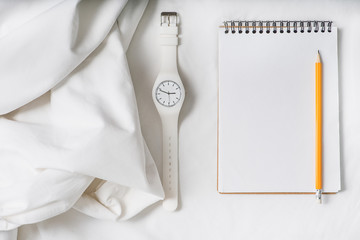 Open notebook near white wristwatch
