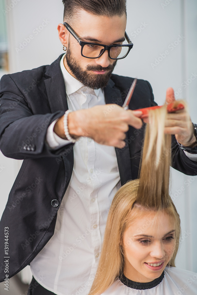 Wall mural Concentrated stylist is working at studio