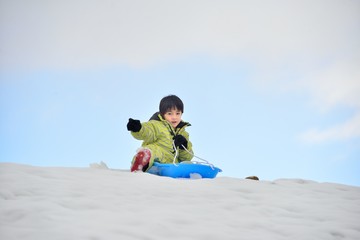 Fototapeta na wymiar 新雪の雪原で遊ぶファミリー