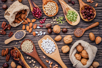 Various legumes and different kinds of nutshells in spoons. Waln