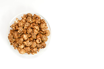 Top view of chocolate popcorn in glass bowl on white background