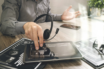 Businessman hand using VOIP headset with digital tablet computer