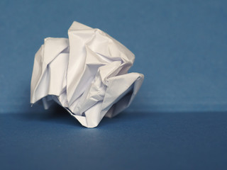 crumpled paper over blue background with copy space