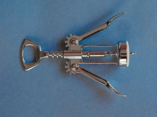 corkscrew and bottle opener over blue