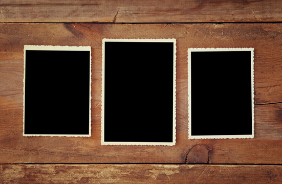 blank photo frames on wooden background