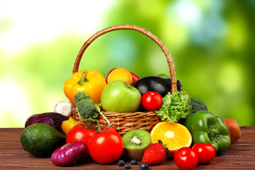 Fresh vegetables and fruits on wooden table against blurred background