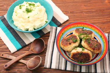 Fried savory tuna patties with potato in the bowl on wooden table