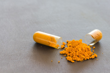 Turmeric powder  in tube and herbal Turmeric capsule on black ba